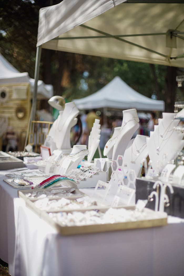 about-me Elegant outdoor jewelry stall showcasing luxury accessories at a market under tents.
