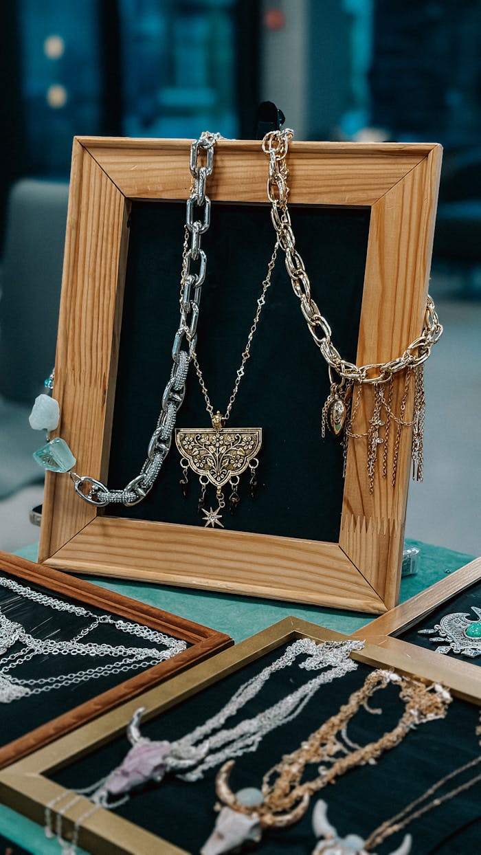 Home Various necklaces elegantly displayed in a wooden frame at a market.